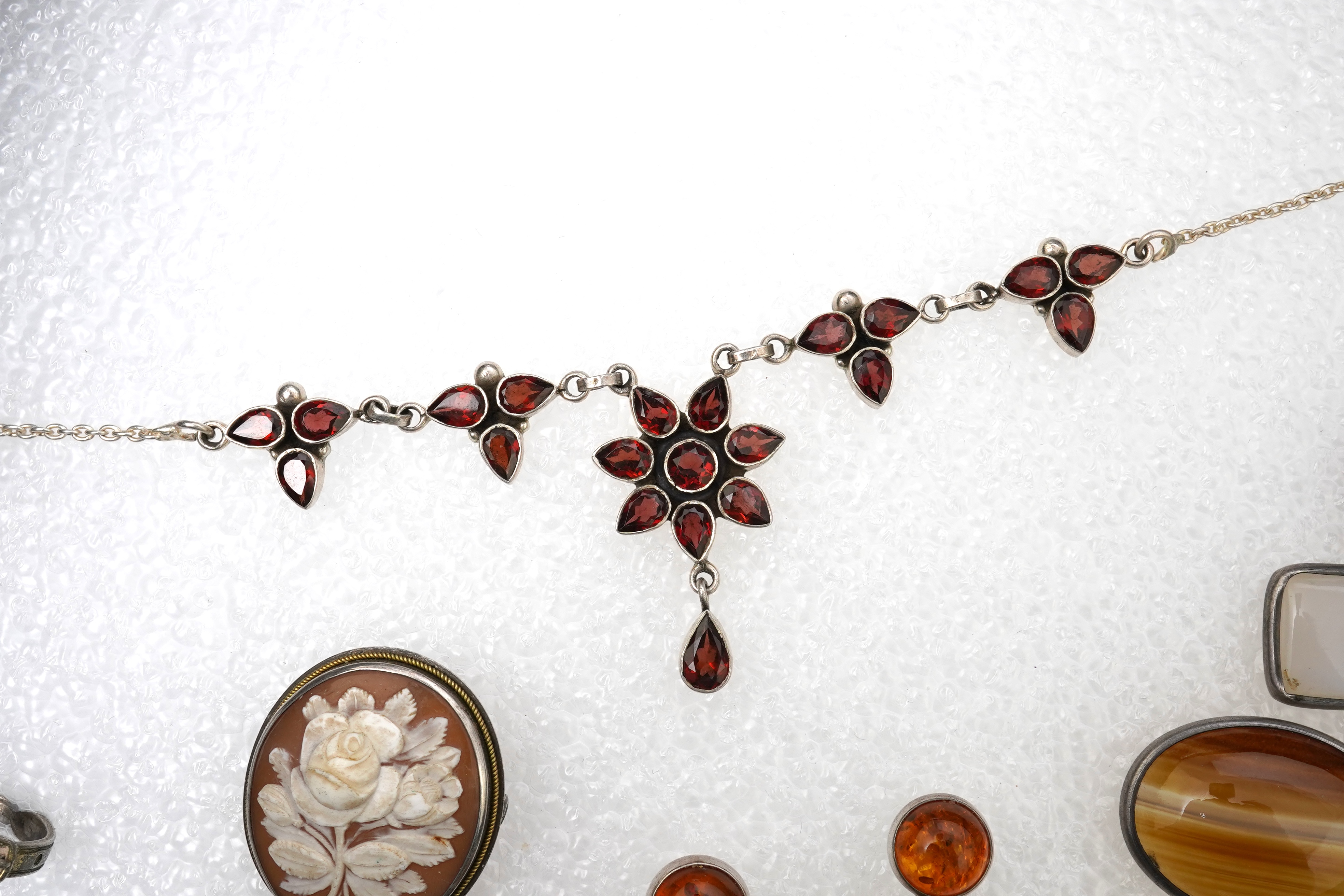 A small collection of costume jewellery to include a silver curb link charm bracelet, hung with assorted bezel set agate and carnelian drops, together with other silver and costume jewellery